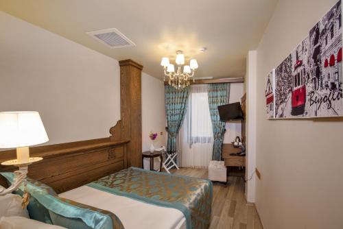 a hotel room with a bed and a chandelier at Perapolis Hotel in Istanbul