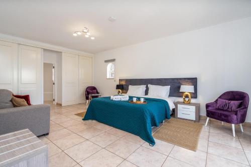 a bedroom with a bed and two purple chairs at Host Wise - Spacious Family House with Garden in Lagos