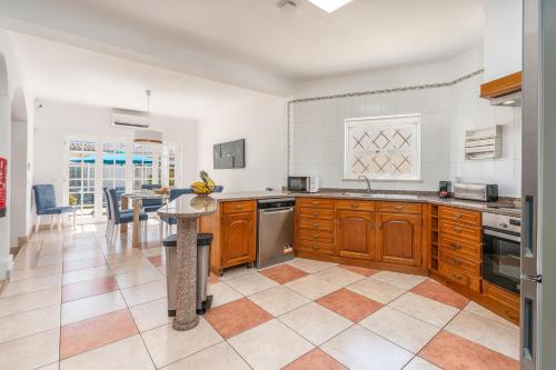 a kitchen with wooden cabinets and a table in it at Host Wise - Spacious Family House with Garden in Lagos