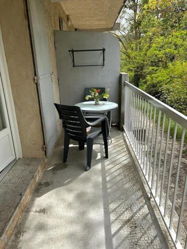 une table et une chaise sur un balcon dans l'établissement T 1 avec terrasse face rivière à 1 min des thermes, à Gréoux-les-Bains
