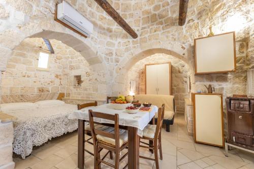 een keuken en eetkamer met een tafel en stoelen bij Villetta Giardino dei Trulli in Ostuni