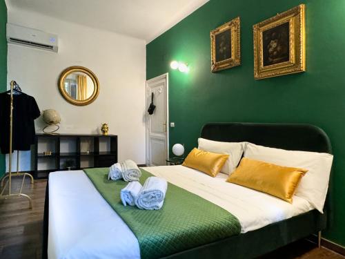 - une chambre verte avec un lit et des serviettes dans l'établissement TP Apartment Luxury Colosseum, à Rome