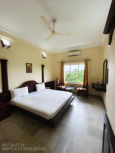 a bedroom with a large bed and a window at Vyshak International in Payyannūr