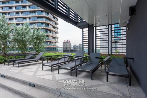 a group of chairs and tables on a building patio at Mossaz at Empire Damansara by Wodages in Kuala Selangor