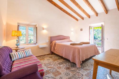un dormitorio con una cama y un sofá en Ca Ses Caretes, en Orient