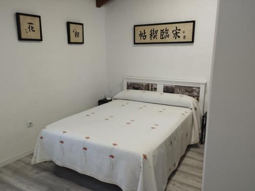 Un dormitorio con una cama blanca en una habitación. en Casa Yuxiao rincón de tranquilidad, en Cádiz