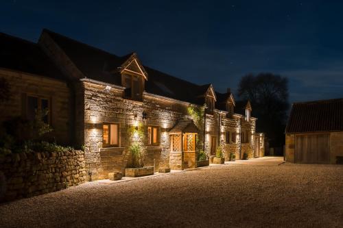 a stone building with lights on it at night at Oker Farm - Luxury farmhouse with hot tub in the Peak District in Matlock
