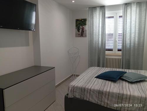 a bedroom with a bed with a dresser and a television at Tra cielo e mare in Capo dʼOrlando