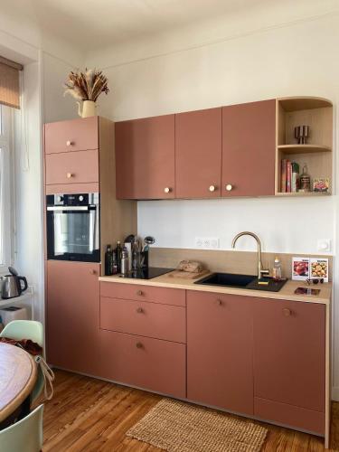 La cuisine est équipée de placards bruns et d'un évier. dans l'établissement L'écume des jours VUE MER, à Dieppe