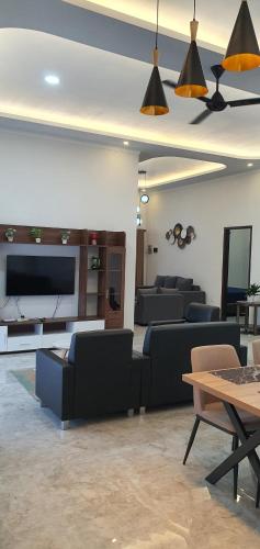 a living room with couches and a flat screen tv at RaYa GuestHouse & Pool in Purwokerto