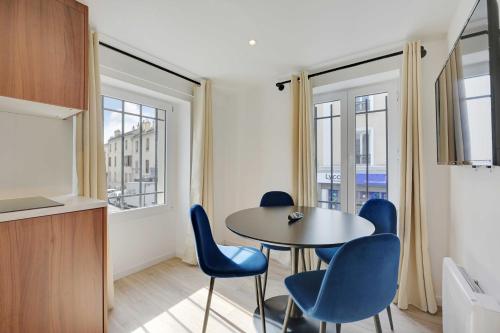 une pièce avec une table, des chaises et des fenêtres dans l'établissement Pleasant and bright apt - 1BD-2P - near Paris, à Aubervilliers