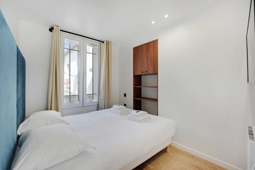 une chambre blanche avec un lit et une fenêtre dans l'établissement Cosy, fully-equipped apt - 1BD-2P - near Paris, à Aubervilliers