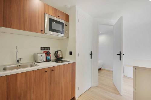 une cuisine avec un évier et un micro-ondes dans l'établissement Cosy, fully-equipped apt - 1BD-2P - near Paris, à Aubervilliers