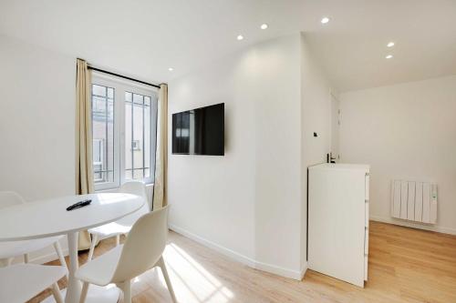 - une salle à manger blanche avec une table et un réfrigérateur dans l'établissement Cosy, fully-equipped apt - 1BD-2P - near Paris, à Aubervilliers