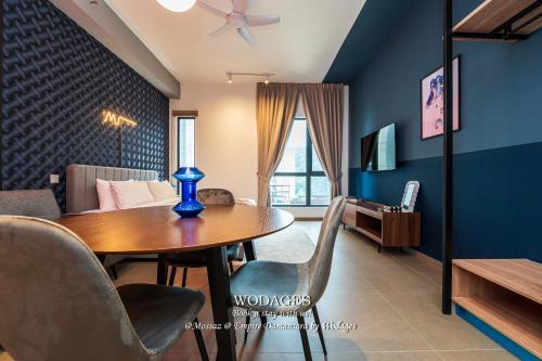 a dining room with a table and a couch at Mossaz at Empire Damansara by Wodages in Kuala Selangor