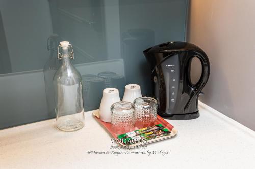a counter top with a blender and glasses and a bottle at Mossaz at Empire Damansara by Wodages in Kuala Selangor