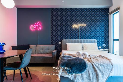 a bedroom with a bed and a chair and a table at Mossaz at Empire Damansara by Wodages in Kuala Selangor