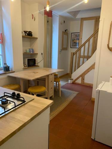 a kitchen with a stove and a table with a counter top at L'ARCADE in Louhans