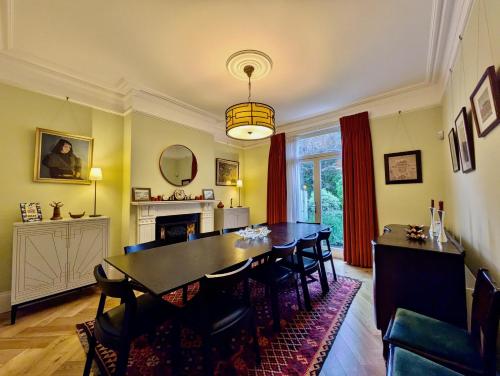 a dining room with a table and chairs at Impressive 5BR family home in Leafy in London