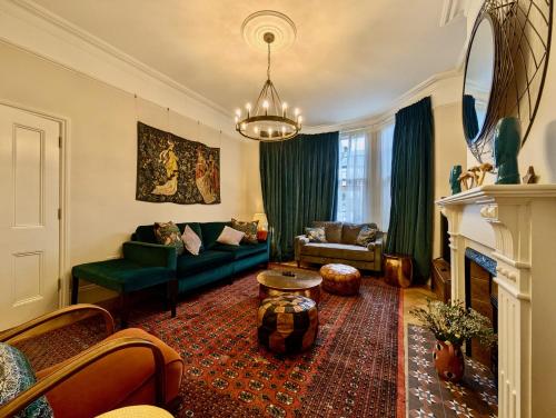 a living room with a green couch and a fireplace at Impressive 5BR family home in Leafy in London