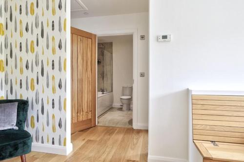 a room with a bathroom with a toilet and a chair at 2 Bed Penthouse Apartment - 14 in Nefyn