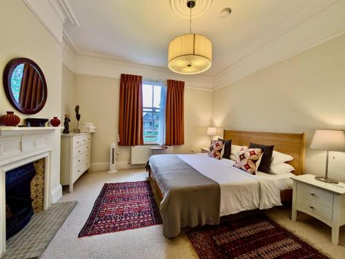 a bedroom with a large bed and a fireplace at Impressive 5BR family home in Leafy in London