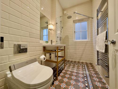 a bathroom with a toilet and a sink at Impressive 5BR family home in Leafy in London