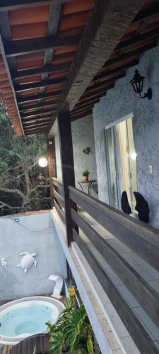 a bath tub on a porch with a bird bathvisor at Pousada Sereia de Geriba in Búzios