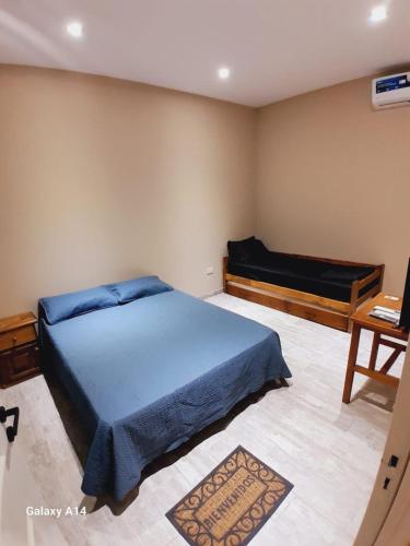 a bedroom with a blue bed and a desk at Piracuacito in Paso de la Patria