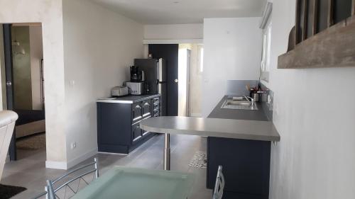 une cuisine avec une cuisinière et un comptoir dans l'établissement Maisonnette au coeur du circuit des 24h du Mans, à Mulsanne