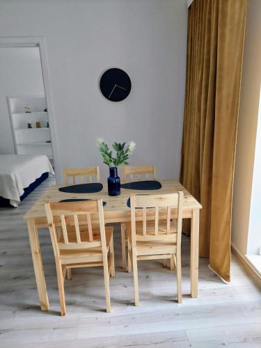 a wooden table with two chairs and a vase on it at Apple Inn in Warsaw