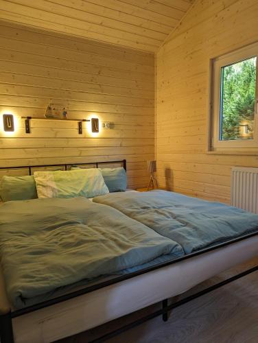 a bed in a room with a wooden wall at Amira in Stuer