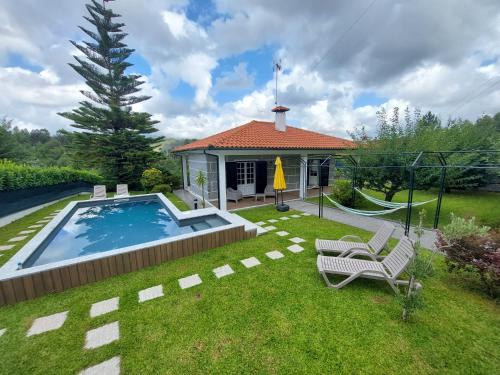 a backyard with a swimming pool and a house at Casa da Marcolininha in Vieira do Minho