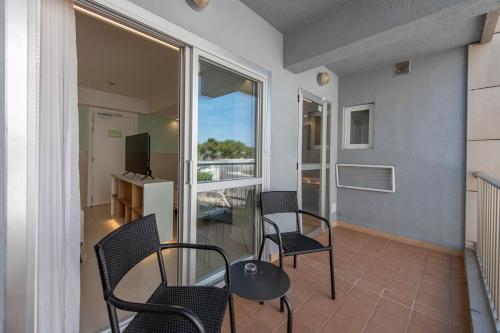 a balcony with chairs and a table and a desk at Bordoy Cosmopolitan in Playa de Palma