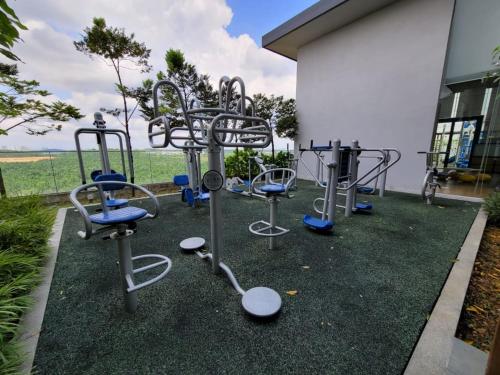 a group of exercise equipment sitting next to a building at B2107 Grand Medini Pool View 100ms Netflix By STAY in Iskandar Puteri