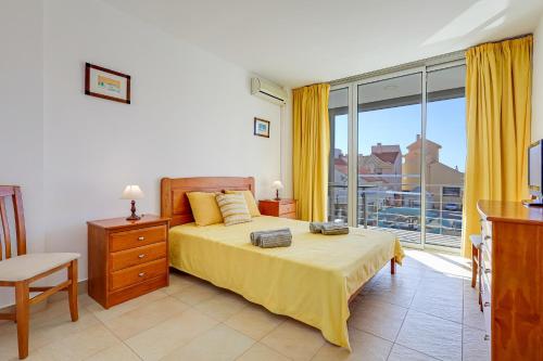 een slaapkamer met een bed en een groot raam bij Apartment with 2 bedrooms at Vilamoura Marina in Quarteira