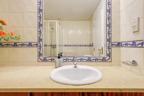 een badkamer met een witte wastafel en een spiegel bij Apartment with 2 bedrooms at Vilamoura Marina in Quarteira