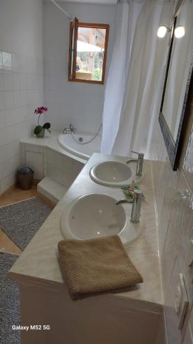 une salle de bain avec deux lavabos et un miroir dans l'établissement Appartement Barsan, à Vaison-la-Romaine