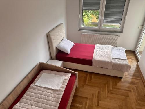une chambre avec deux lits et une fenêtre dans l'établissement Apartment near airport II, à Sarajevo