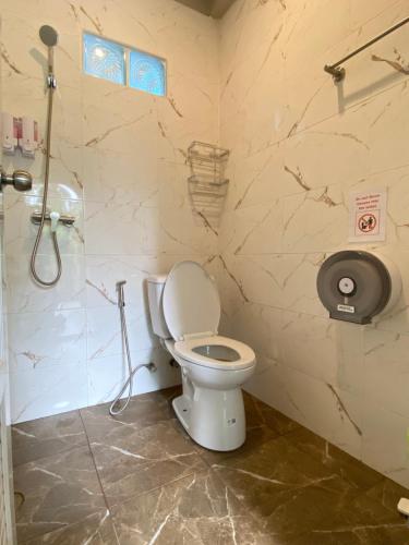 a bathroom with a toilet and a shower at Flora Hostel KhaoSok in Khao Sok