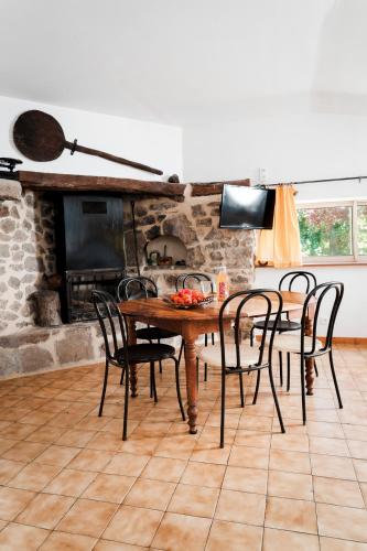 une salle à manger avec une table et des chaises et une cheminée dans l'établissement DOMAINE DU VERNADEL, à Asperjoc