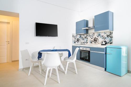 a kitchen with a table and chairs and a tv at Olleia Home in Vico Equense
