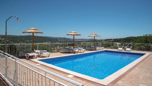 a pool on a balcony with umbrellas and chairs at Casa Quadra Dique in Faro