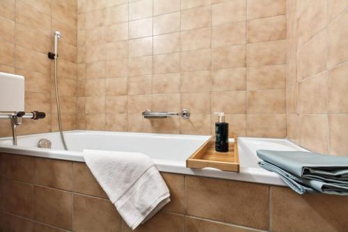 a bathroom with a bath tub and a sink at Beautiful Boutique Apartment DRAHTZUG8 in Zürich
