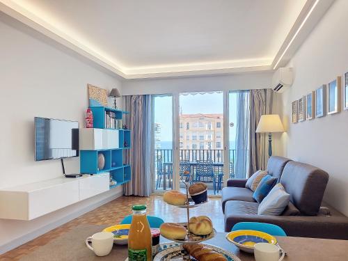 un salon avec un canapé et une télévision dans l'établissement Nestor&Jeeves - BLEU AZUR VUE MER - Central - Very close sea, à Nice