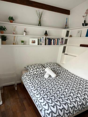- une chambre avec un lit noir et blanc et des étagères dans l'établissement Appartement cosy près du Panthéon, à Paris