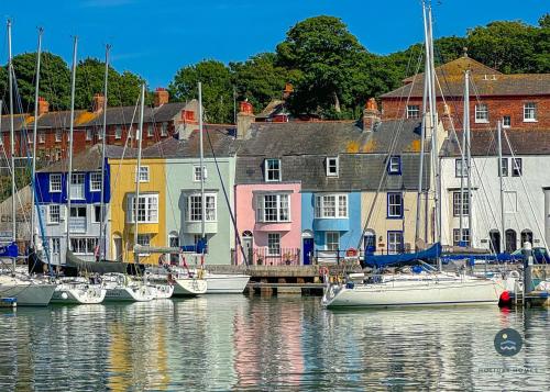 a group of boats are docked in a harbor at 14 Nothe Parade - Waterfront Holiday Cottage in Weymouth