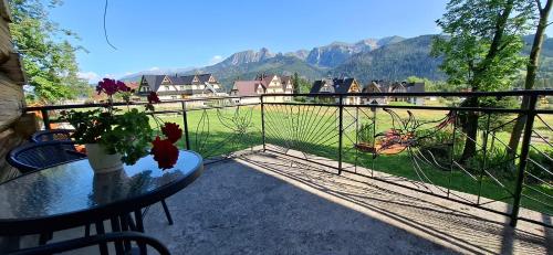 a balcony with a table and a view of the mountains at Domek, Apartamenty i pokoje Willa Elita in Kościelisko