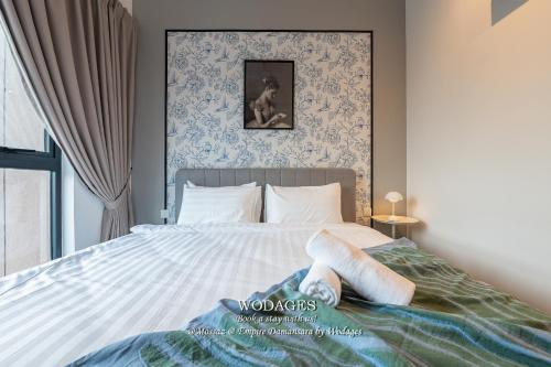 a bedroom with a large bed with a picture on the wall at Mossaz at Empire Damansara by Wodages in Kuala Selangor