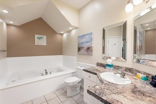 a bathroom with a tub and a toilet and a sink at Surreal Views #328 Beach Pool AC Hot Tub in Traverse City